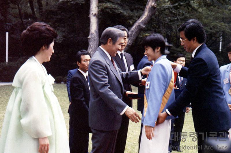 본문 이미지 - 제13대 대통령을 지낸 노태우 전 대통령이 26일 지병 악화로 별세했다. 향년 89세. 고인은 1987년 6월 항쟁 직후 집권 민정당(민주정의당) 대선 후보로서 '6·29 선언'을 발표해 대통령 직선제를 받아들인 뒤 그해 12월 13대 대선에서 당선된, 대통령 직선제 도입 후 첫 대통령이었다. 사진은 1988년 88올림픽 선수단 훈장 수여하는 노 전 대통령 모습. (대통령기록관 홈페이지 캡처) 2021.10.26/뉴스1