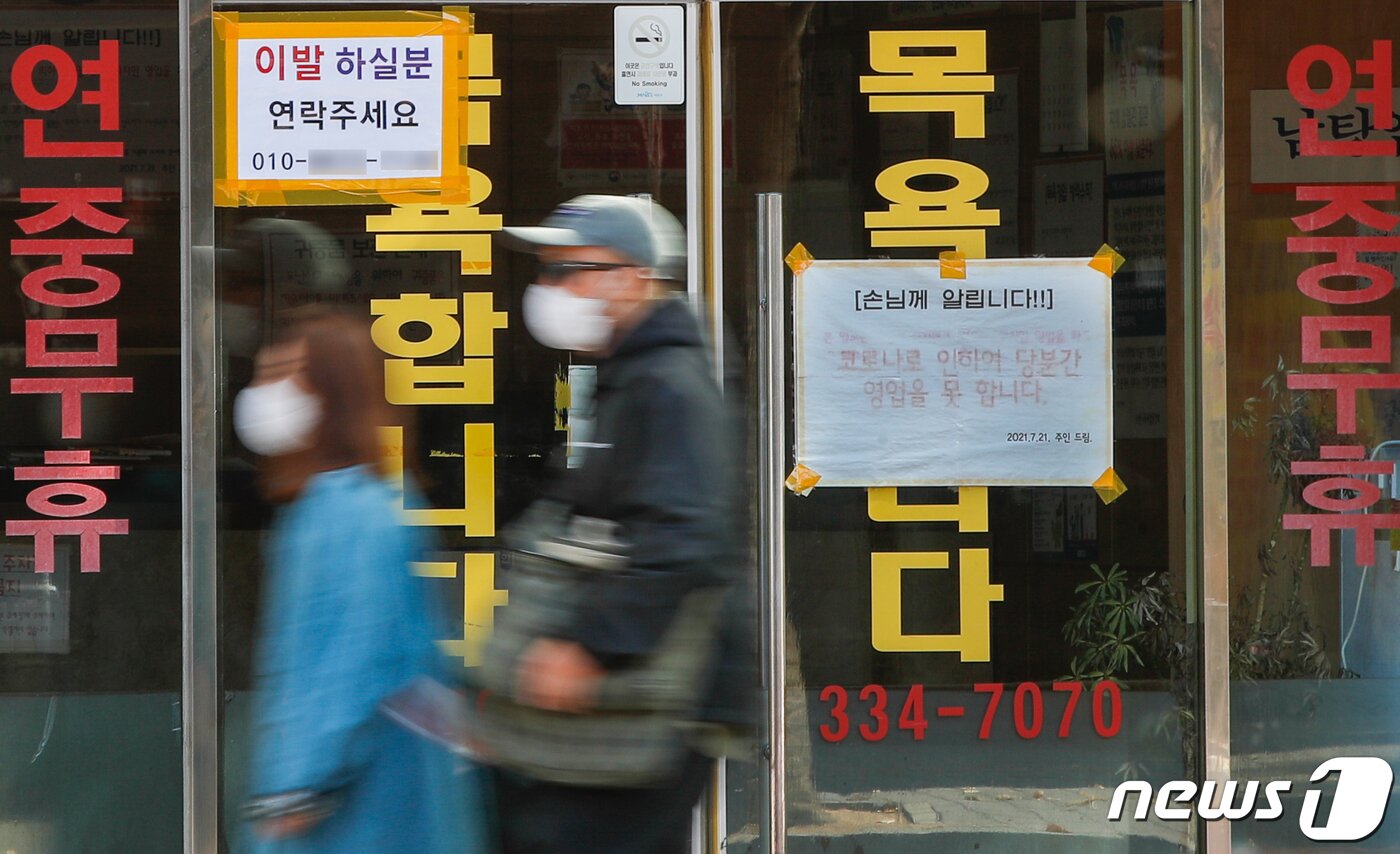 본문 이미지 - 단계적 일상회복(위드 코로나)을 앞둔 27일 서울시내 사우나 시설에 '코로나로 인하여 당분간 영업을 못 합니다'라는 안내문이 붙어있다. 내달 1일부터 노래연습장과 목욕장업, 실내체육시설은 접종 증명·음성확인제(백신패스)를 도입하는 대신 시간제한은 해제한다. 접종증명·음성확인제(백신 패스)는 예방접종 이력을 확인하거나, 48시간 이내 유전자 증폭(PCR) 음성확인서를 소지한 사람만 다중이용시설 출입을 허용하는 제도다. 2021.10.27/뉴스1 ⓒ News1 안은나 기자