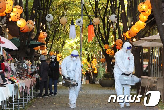 핼러윈 데이를 나흘 앞둔 27일 오후 경기도 용인시 기흥구 보정동 카페거리에서 기흥구보건소 관계자들이 방역 작업을 하고 있다. 김영운 기자