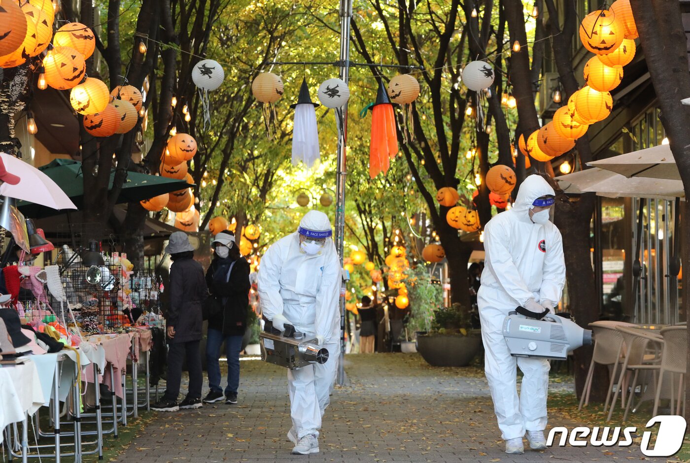 핼러윈 데이를 나흘 앞둔 27일 오후 경기도 용인시 기흥구 보정동 카페거리에서 기흥구보건소 관계자들이 방역 작업을 하고 있다. 김영운 기자