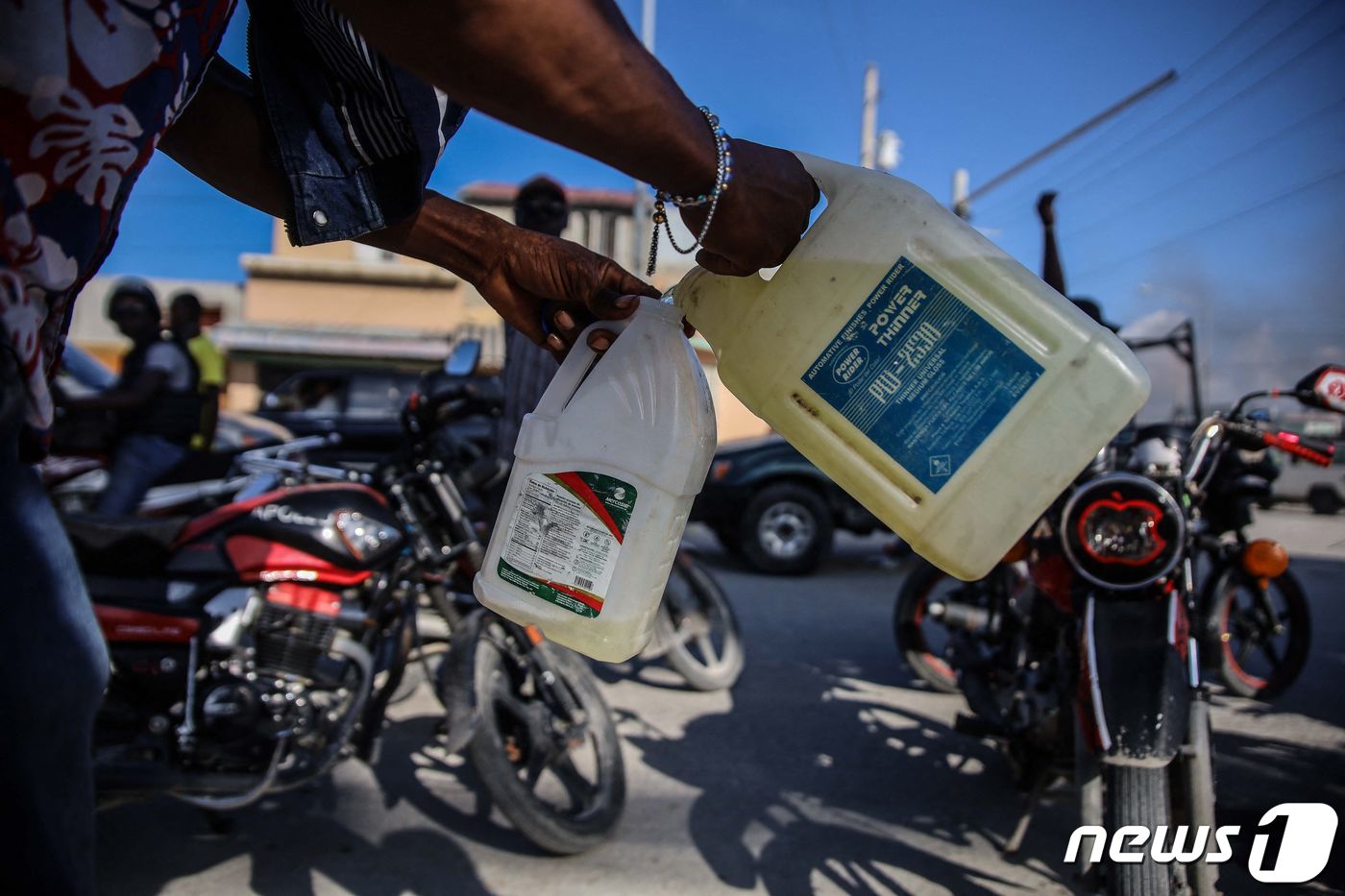 (포르토프랭스 AFP=뉴스1) 신윤하 기자 = 26일(현지시간) 아이티 포르토프랭스에서 총파업과 연료난 등 혼란이 커지는 가운데 사람들이 휘발유를 구매해 되팔고 있다.ⓒ AFP=뉴 …