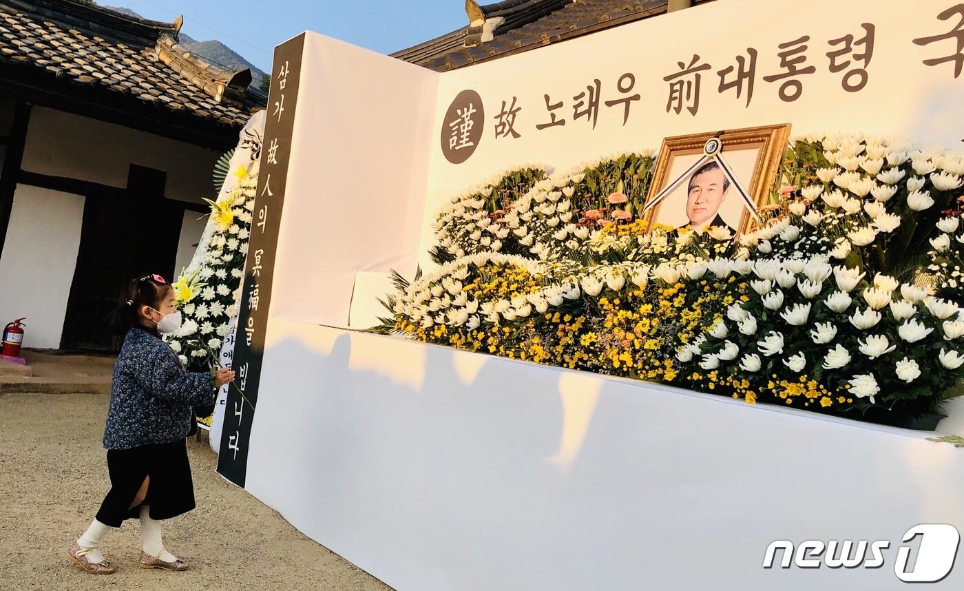 본문 이미지 - 27일 대구 동구 신용동 '용진마을'에 위치한 고(故) 노태우 전 대통령 생가에 설치된 분향소를 찾은 시민들이 노 전 대통령 영정 사진에 헌화하며 조문하고 있다. 2021.10.27/뉴스1 ⓒ News1 남승렬 기자
