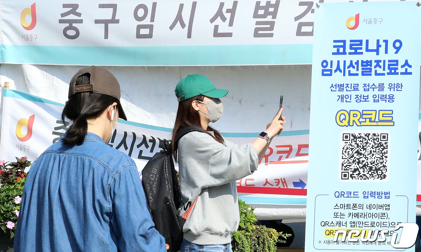 본문 이미지 - 서울 중구 서울역광장에 마련된 코로나19 임시선별진료소를 찾은 시민들이 검체검사 전 QR코드 입력을 하고 있다.ⓒ News1 김진환 기자