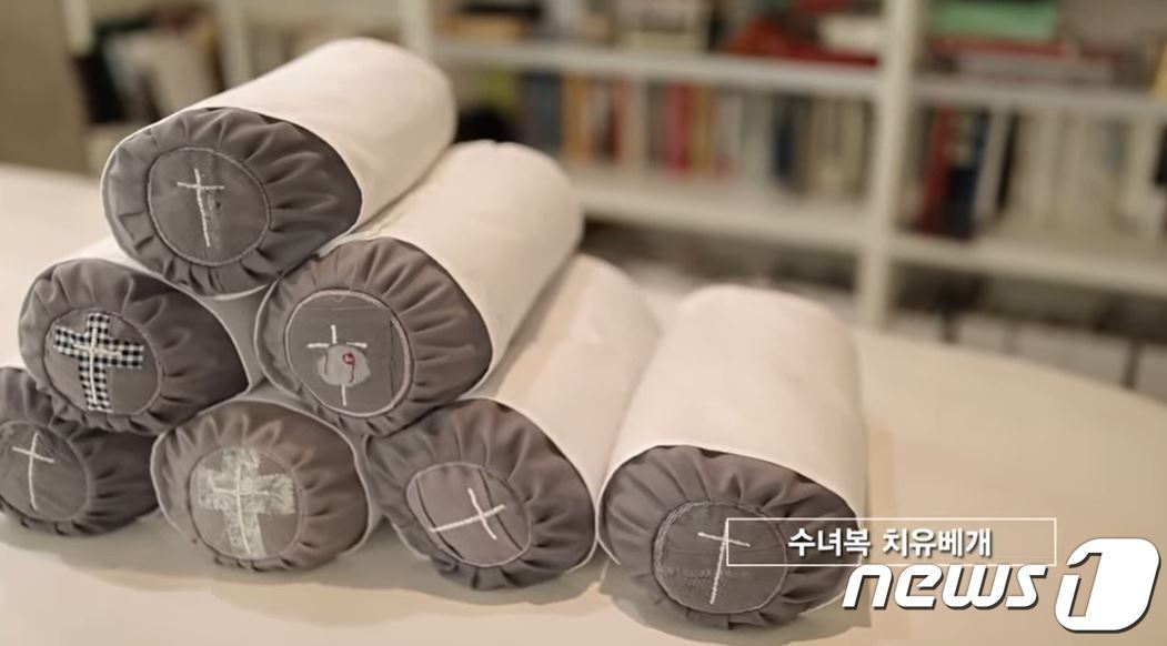 본문 이미지 - 기증받은 수녀복으로 만든 베개. 박용만 대한상공회의소 명예회장이 기획하고 김영진(차이킴) 한복 디자이너가 제작했다.<'수녀복, 기도와 치유로 부활하다' 유튜브 동영상 캡처>ⓒ 뉴스1