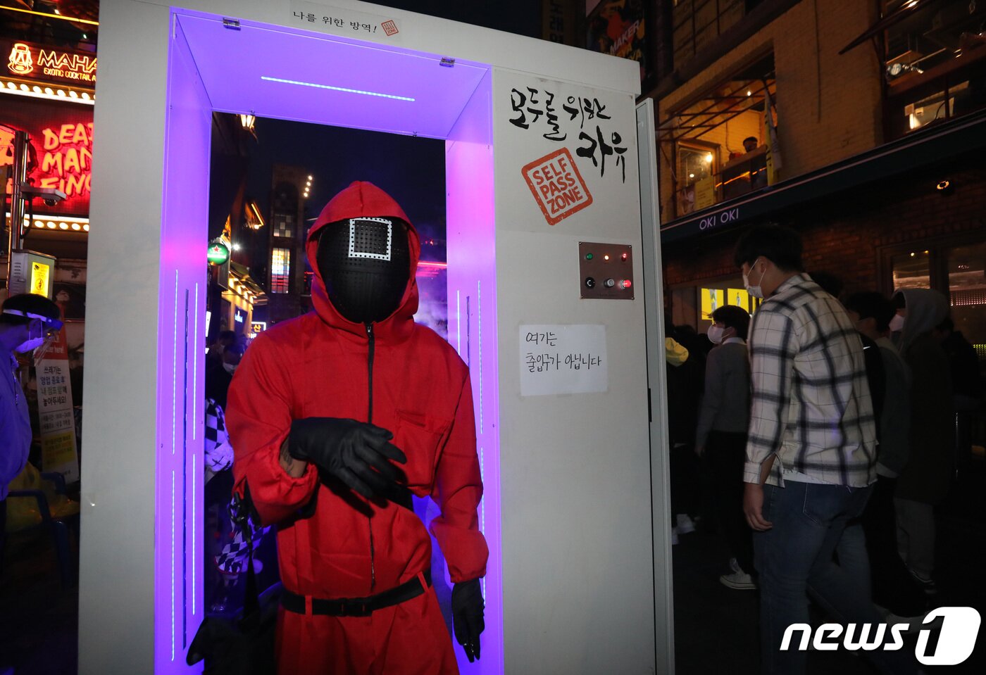본문 이미지 - 핼러윈데이인 31일 오후 서울 이태원 거리를 찾은 시민이 '오징어 게임' 복장을 한 채 방역게이트를 지나가고 있다. 2021.10.31/뉴스1 ⓒ News1 박지혜 기자