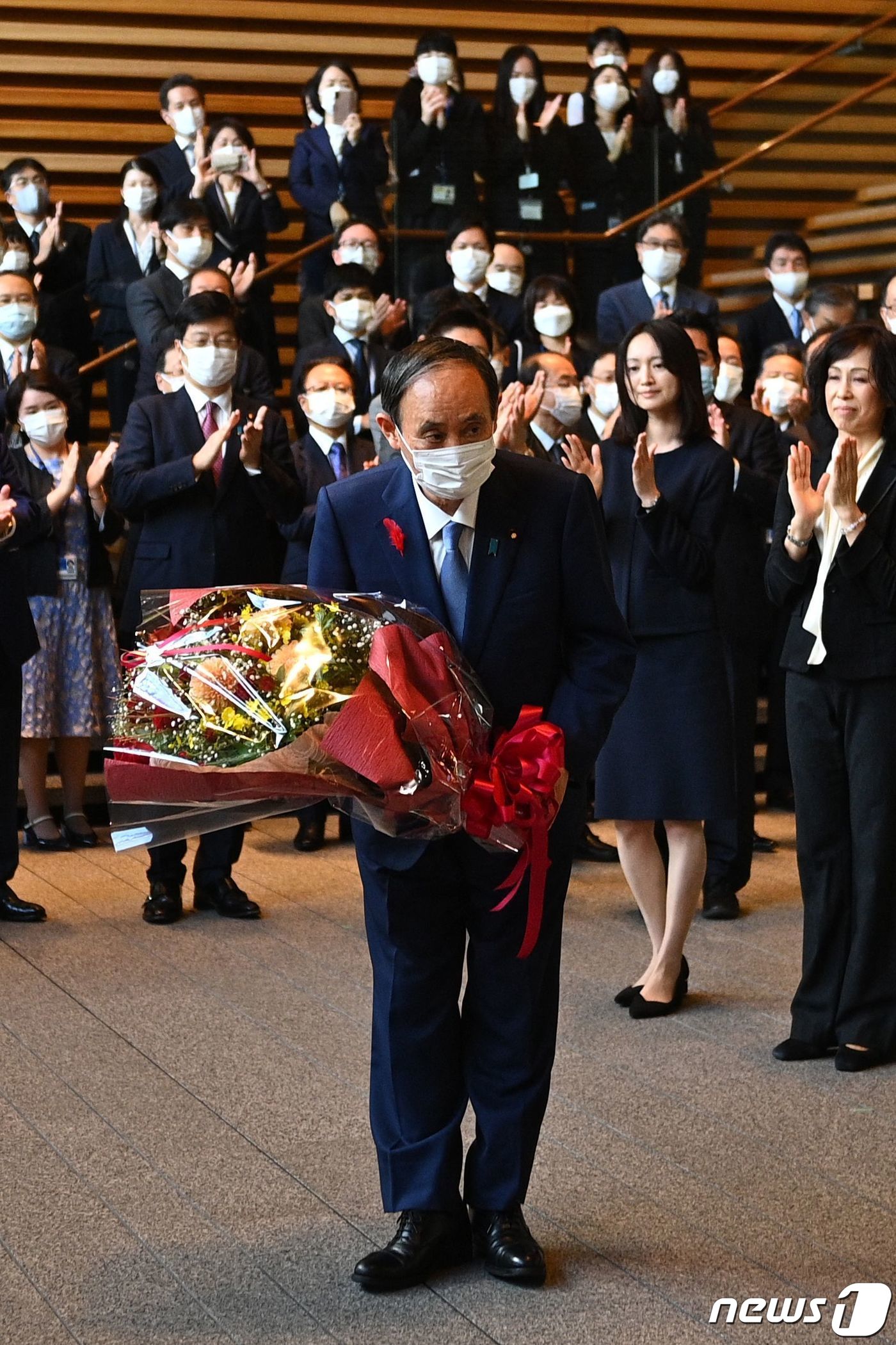 (도쿄 AFP=뉴스1) 우동명 기자 = 물러나는 스가 요시히데 일본 총리가 4일 (현지시간) 도쿄 총리 관저에서 마지막 각료회의를 마친 뒤 꽃다발을 받고 있다.ⓒ AFP=뉴스1
