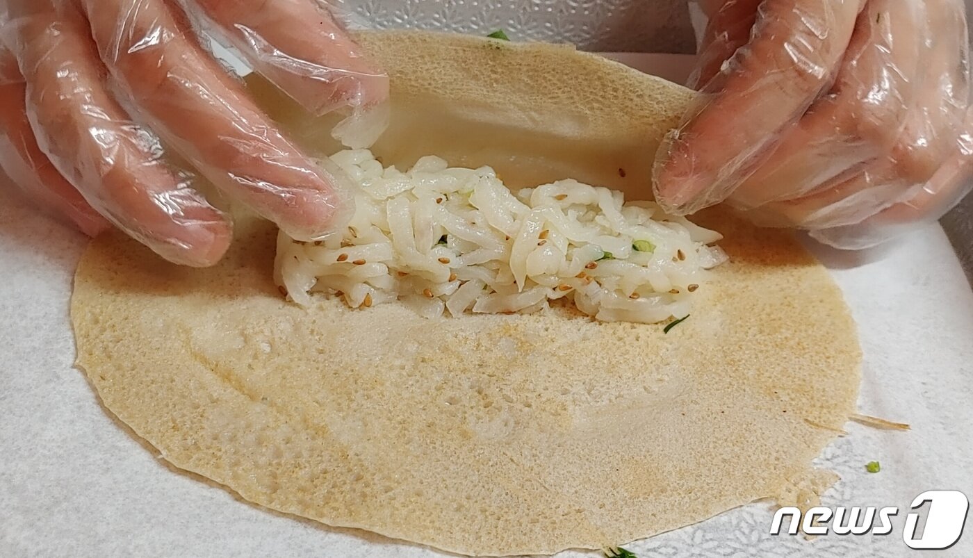 본문 이미지 - 빙떡은 메밀로 만든 전병에 삶은 무채와 마늘, 깨소금, 참기름 등을 썪은 소를 넣어 말아서 만든다.  ⓒ 뉴스1