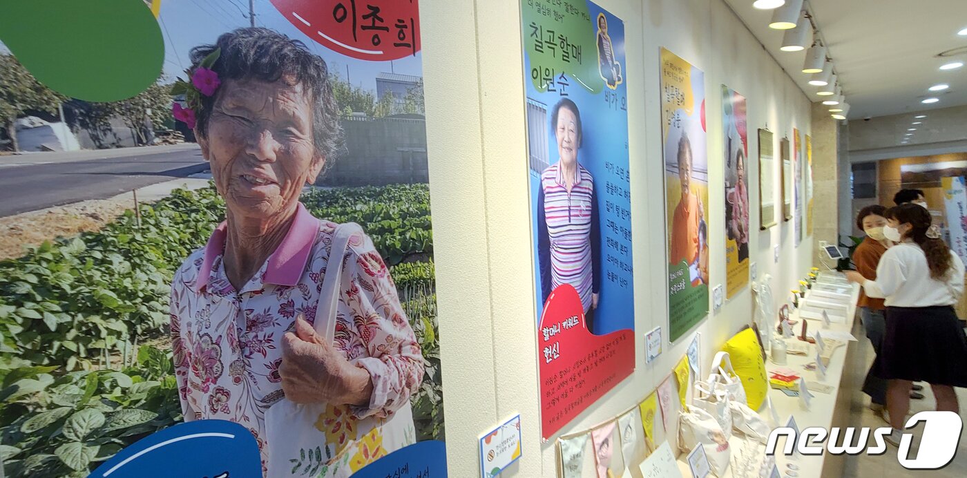 본문 이미지 - 한글날을 앞둔 6일 '칠곡할매글꼴'의 의미와 가치를 알리고 한글 사랑운동 확산을 위해 경북 칠곡군이 군청 갤러리에서 연 '칠곡할매 굿즈 전시회'를 군민들이 구경하고 있다. 칠곡군은 이날 훈민정음에 형식을 빌어 국민들이 널리 편하게 칠곡할매글꼴을 이용하라는 의미를 담은 '용민정음(用民正音)'을 발표했다. 2021.10.6/뉴스1 ⓒ News1 정우용 기자