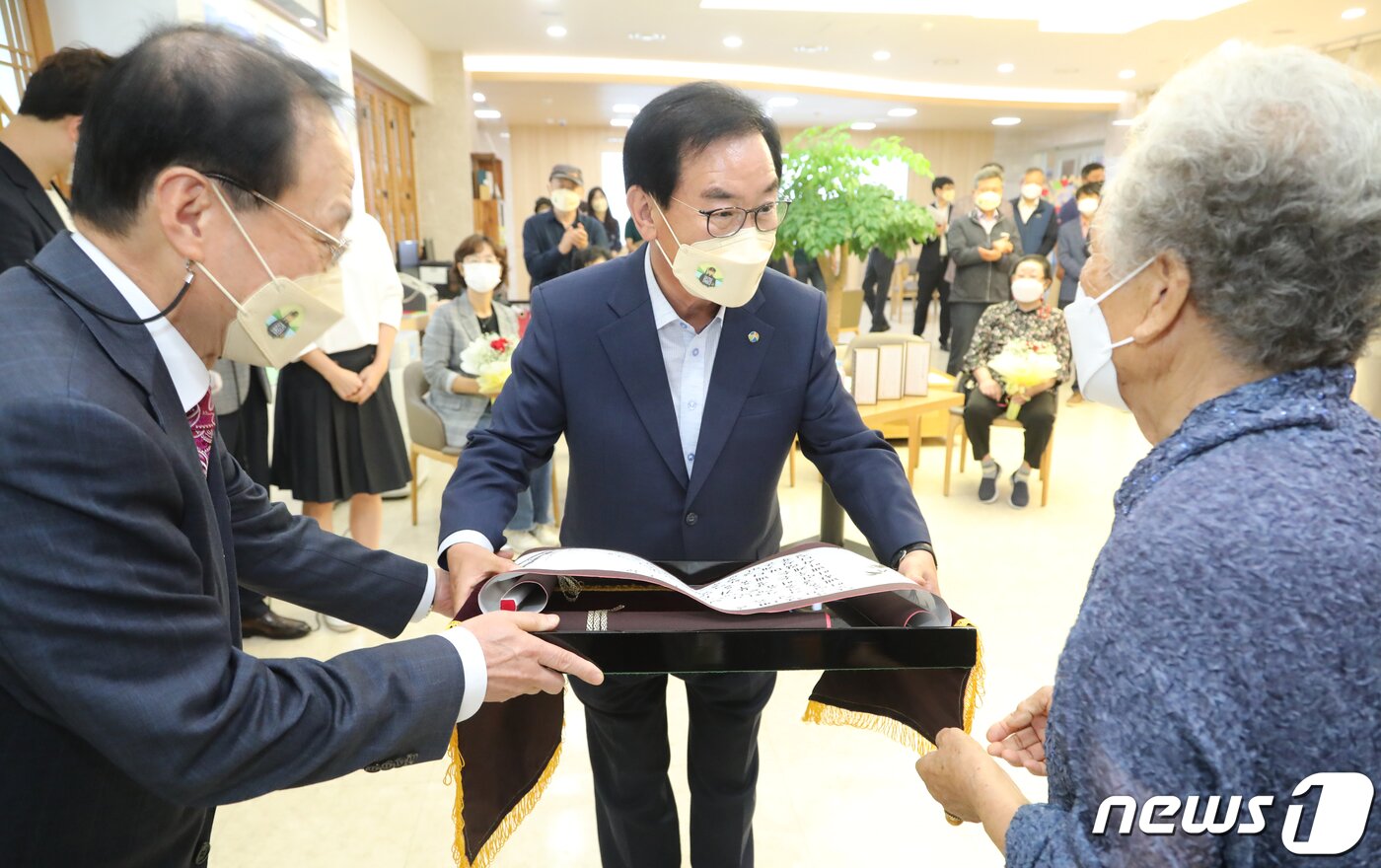 본문 이미지 - 한글날을 앞둔 6일 '칠곡할매글꼴'의 의미와 가치를 알리고 한글 사랑운동 확산을 위해 경북 칠곡군이 군청 갤러리에서 연 '칠곡할매 굿즈 전시회'에서 추유을 할머니가 '칠곡할매글꼴선언문인 용민정음을 낭독한 뒤 백선기 군수에게 선언문을 전달하고 있다. 칠곡군은 이날 훈민정음에 형식을 빌어 국민들이 널리 편하게 칠곡할매글꼴을 이용하라는 의미를 담은 '용민정음(用民正音)'을 발표했다. 2021.10.6/뉴스 ⓒ News1 정우용 기자