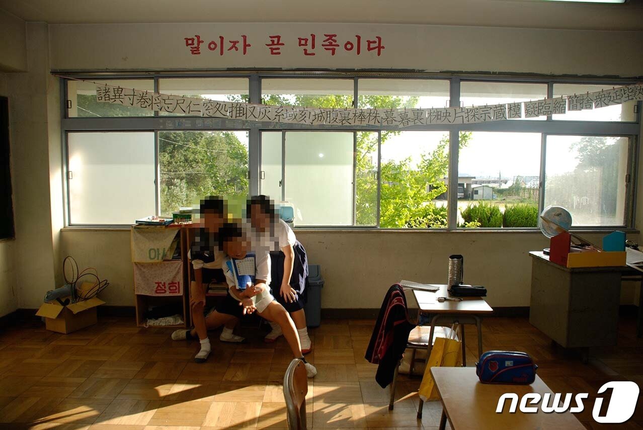 본문 이미지 - 2007년에 찍은 어느 조선학교 교실. ‘말이자 곧 민족이다’라는 표어가 선명하다.ⓒ 뉴스1