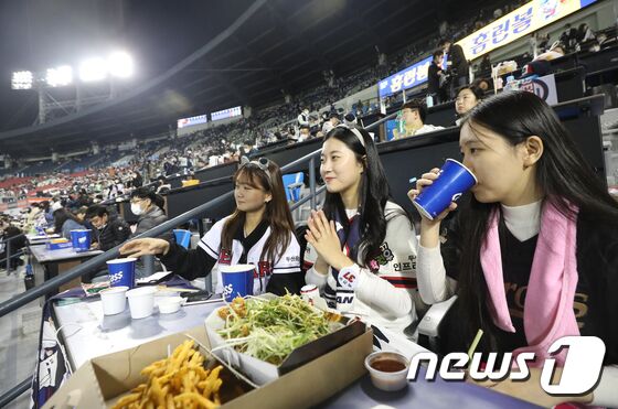 1일 오후 서울 송파구 잠실야구장에서 열린 프로야구 '2021 신한은행 SOL KBO 포스트시즌‘ 와일드카드 결정전 1차전 키움 히어로즈와 두산 베어스의 경기에서 관중들이 치맥을 먹으며 응원을 하고 있다. 이번 포스트시즌 전 경기는 '전 좌석 접종자 구역'으로 운영된다. 이에 따라 백신 2차 접종 후 2주가 경과한 백신 접종 완료자를 포함한 48시간 내 PCR 음성확인자, 18세 이하, 불가피한 사유의 접종 불가자(의사 소견서 필요)도 입장이 가능하다. 2021.11.1/뉴스1 © News1 임세영 기자