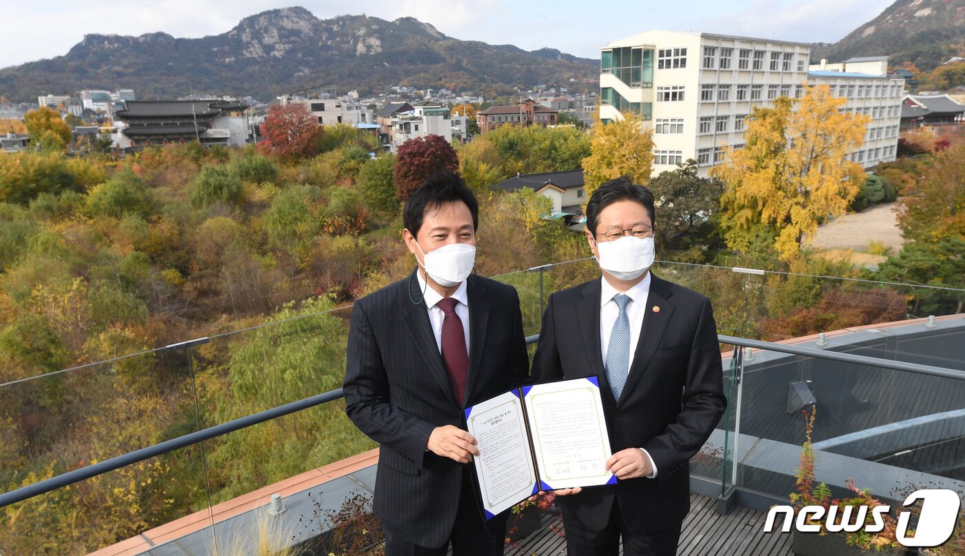 본문 이미지 - 오세훈 서울시장(왼쪽)과 황희 문화체육관광부 장관이 10일 종로구 서울공예박물관 전망대에서 이건희 기증관 건립을 위한 업무협약서‘를 들고 기념촬영을 하고 있다. 오 시장과 황 장관 뒤로 보이는 부지가 이건희 기증관이 들어설 송현동 부지. 2021.11.10/뉴스1 ⓒ News1 안은나 기자