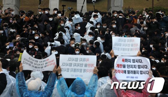 윤석열 국민의힘 대선후보가 10일 오후 광주 북구 운정동 국립5·18민주묘지에서 광주전남대학생진보연합 관계자 등에 막혀 길을 뚫고 있다. 2021.11.10/뉴스1 © News1 이동해 기자