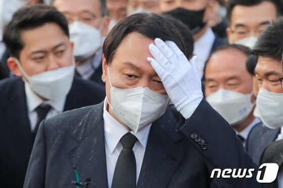 윤석열 국민의힘 대선 후보가 광주 북구 국립5·18민주묘지에서 추모탑과 묘역에 진입하지 못하고 참배광장에서 묵념을 한 뒤 머리를 만지고 있다. 2021.11.10/뉴스1 © News1 이동해 기자