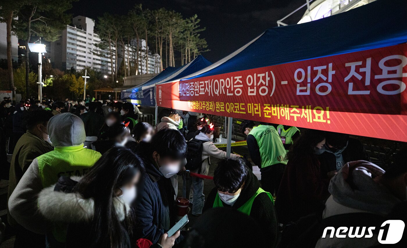 본문 이미지 - 11일 오후 2022 국제축구연맹(FIFA) 카타르 월드컵 최종예선 대한민국과 아랍에미리트(UAE)의 경기가 열리는 경기도 고양시 고양종합운동장을 찾은 관람객들이 입장을 위해 백신접종완료 인증을 하고 있다. 그동안 신종 코로나바이러스 감염증(코로나19) 여파로 무관중 혹은 제한 유관중 입장만 허용됐지만 이번 A매치부터는 정부의 단계적 일상회복에 발맞춰 100% 입장이 가능하다. 국내 A매치 100% 관중 입장은 2019년 12월 동아시아축구연맹(EAFF) E-1챔피언십 이후 약 2년 만이다. 2021.11.11/뉴스1 ⓒ News1 이승배 기자