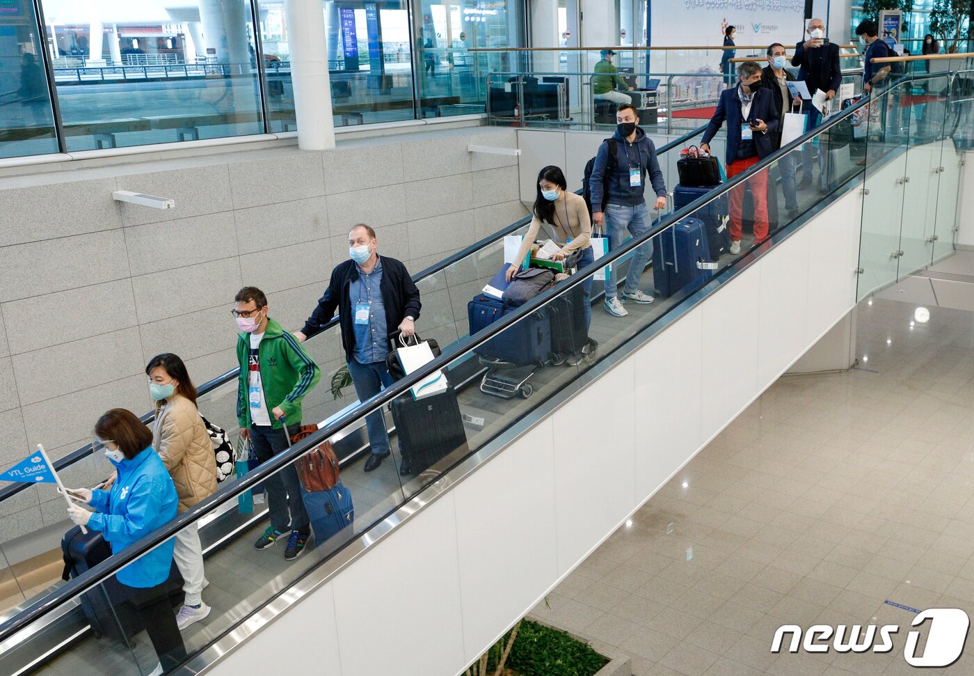 본문 이미지 - 15일 인천국제공항 2터미널을 통해 입국한 싱가포르발 여행객들이 안내를 받으며 이동하고 있다. 한국-싱가포르 간 여행안전권역(트래블 버블)이 이날부터 시행됨에 따라 백신 접종을 완료한 양국 국민들은 격리부담 없이 여행을 할 수 있다. 2021.11.15/뉴스1 ⓒ News1 안은나 기자