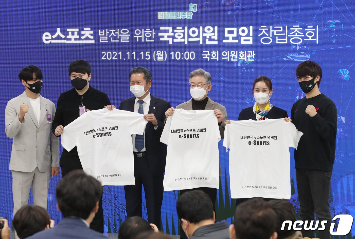 본문 이미지 - 이재명 더불어민주당 대선 후보가 15일 오전 서울 여의도 국회 의원회관에서 열린 'e스포츠 발전을 위한 국회의원 모임 창립총회'에서 참석자들과 기념티셔츠를 들고 포즈를 취하고 있다. 2021.11.15/뉴스1 ⓒ News1 구윤성 기자