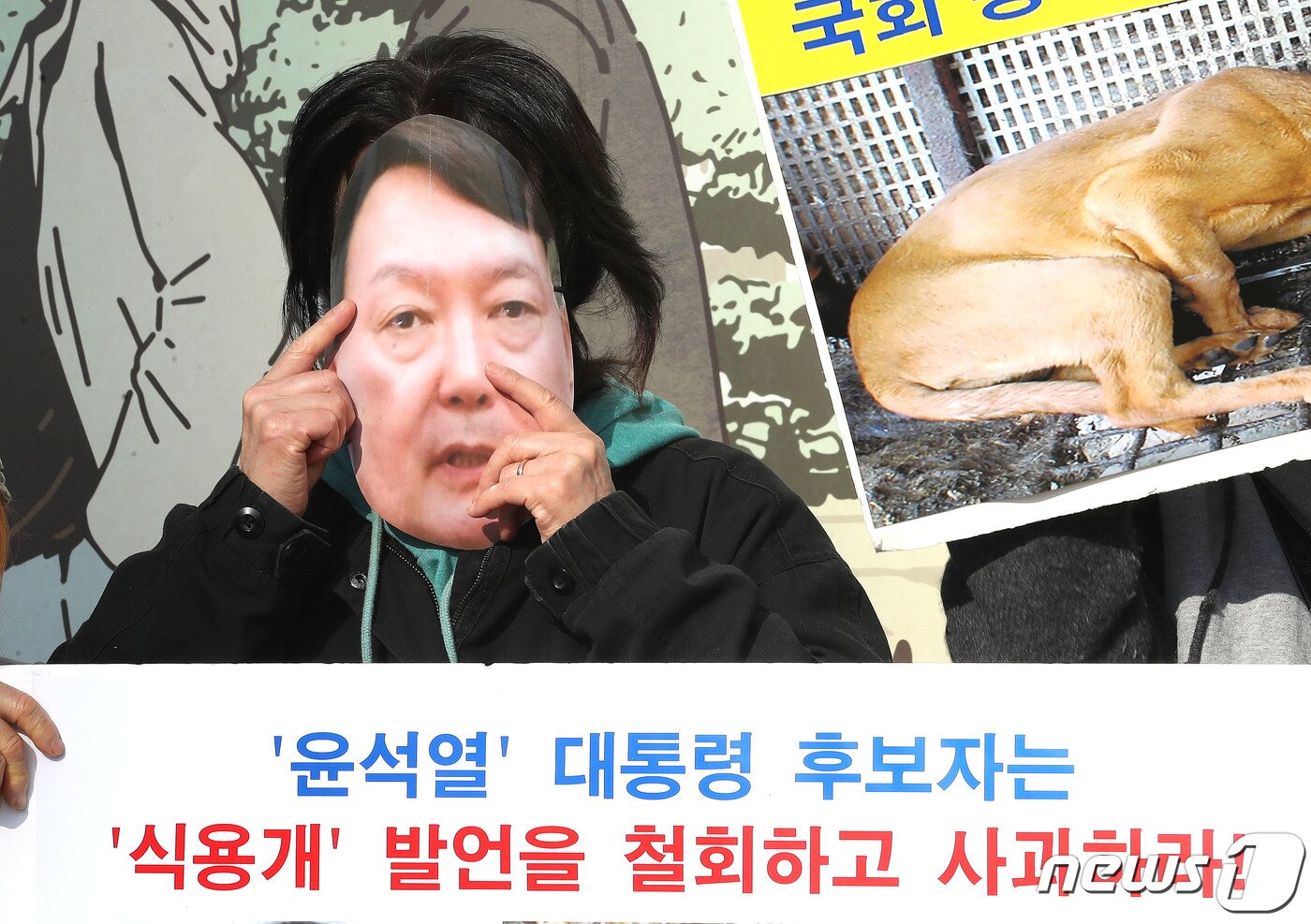 본문 이미지 - 한국동물보호연합 관계자가 16일 서울 종로구 광화문 네거리에서 기자회견을 갖고 지난달 31일 제10차 국민의힘 대선 경선 합동토론회에서 '식용개는 따로 있다'는 윤석열 후보의 발언을 규탄하며 '개식용 금지'를 포함한 동물복지 정책공약을 촉구하는 퍼포먼스를 위해 윤석열 후보의 얼굴 가면을 쓰고 있다. 2021.11.16/뉴스1 ⓒ News1 임세영 기자