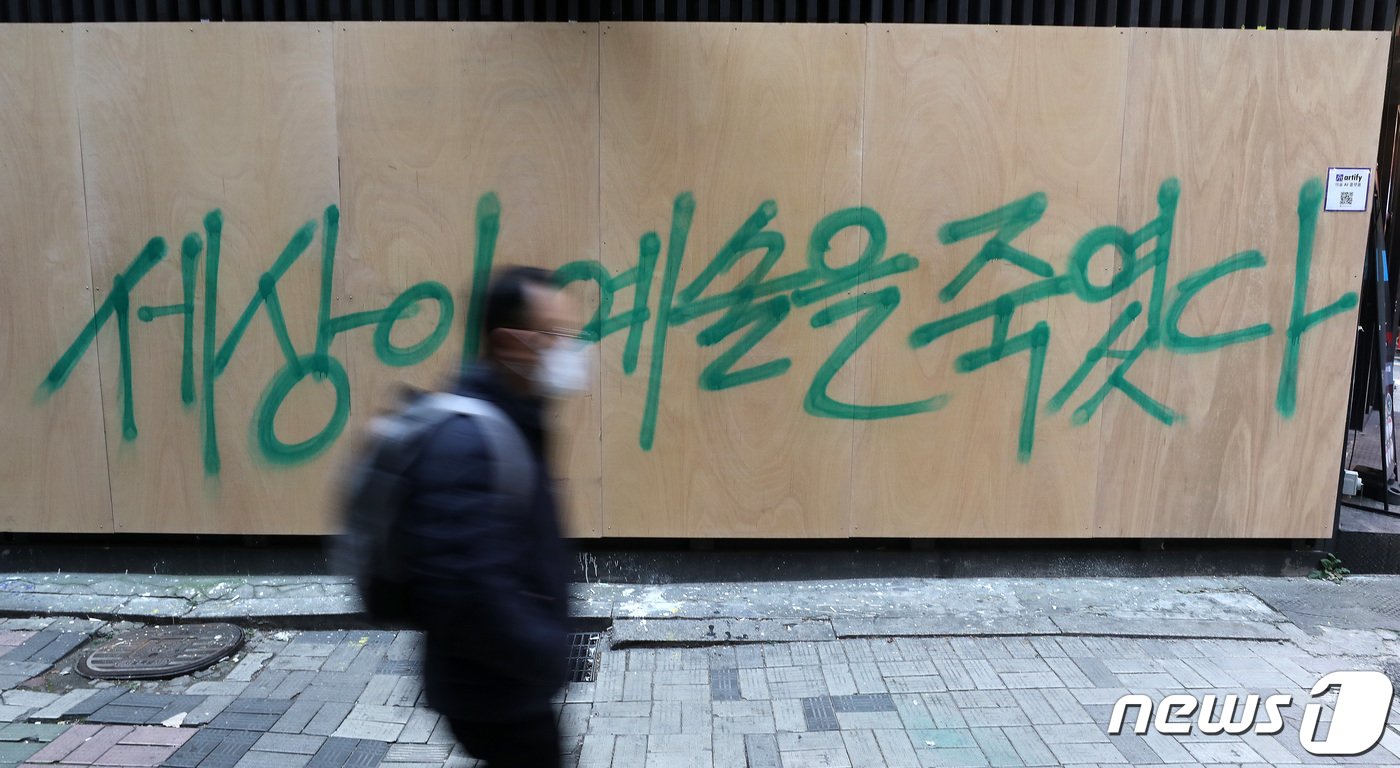 본문 이미지 - 17일 오후 서울 종로구에 위치한 한 중고서점 외벽에 그려져있던 윤석열 국민의힘 대선 후보와 관련된 벽화가 판자로 가려져있다. 가려진 판자 위에 '세상이 예술을 죽였다'라는 문구가 써 있다. 가려지기 전 외벽에는 '손바닥 왕', '개 사과', '전두환 옹호' 논란의 키워드 벽화와 함께 옥외집회 신고 접수증이 부착돼 있었다. 2021.11.17/뉴스1 ⓒ News1 박세연 기자