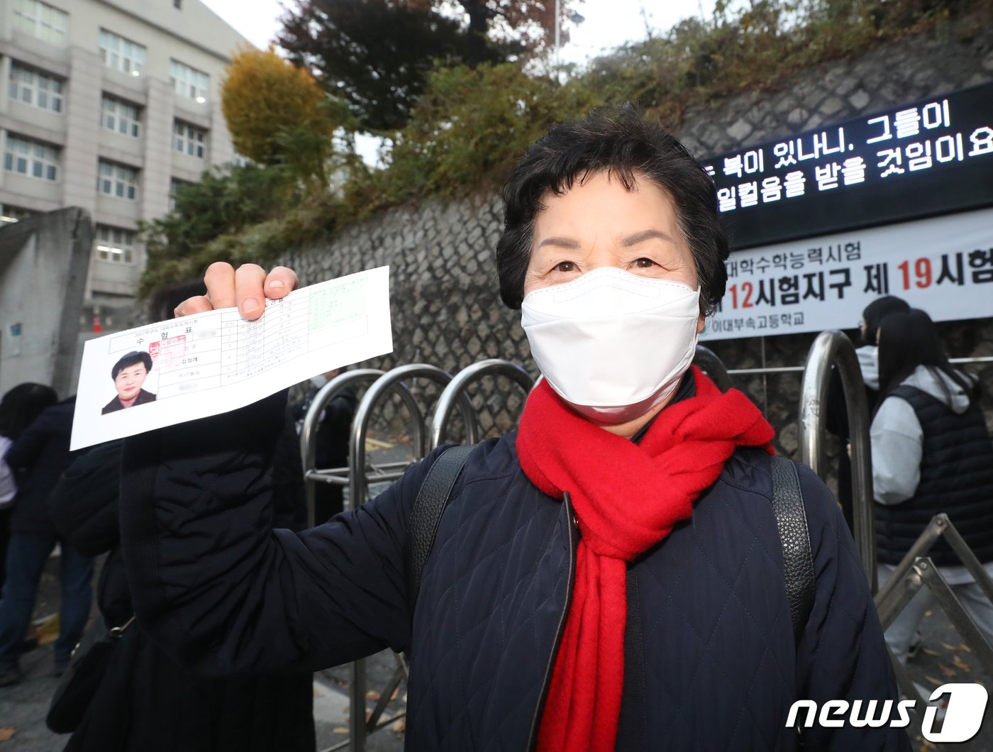 본문 이미지 - 2022학년도 대학수학능력시험일인 18일 오전 서울 서대문구 이대부속이화금란고등학교에서 수능 수험생인 김점례(74세) 할머니가 수험표를 들어보이고 있다. 신종 코로나바이러스 감염증(코로나19) 여파 속 두 번째 대학수학능력시험(수능)은 지난해보다 1만6387명 증가한 50만9821명이 응시한 가운데 전국 86개 지구 1396개 시험장에서 일제히 치러진다. 2021.11.18/뉴스1 ⓒ News1 송원영 기자