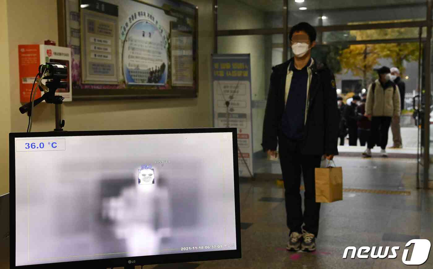 2022학년도 대학수학능력시험일인 18일 오전 서울 용산고등학교에서 수험생들이 시험장에 들어서며 발열체크를 하고 있다. 지난해에 이어 두 번째로 신종 코로나바이러스 감염증(코로나19) 여파 속에서 치러지는 이번 대학수학능력시험(수능)은 지난해보다 1만6387명 증가한 50만9821명이 응시한 가운데 전국 86개 시험지구 1300여개 시험장에서 일제히 치러진다. 2021.11.18/뉴스1 © News1 사진공동취재단