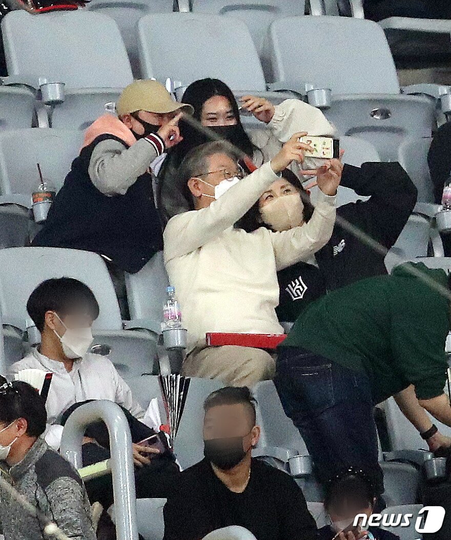 본문 이미지 - 이재명 더불어민주당 대선 후보와 부인 김혜경 씨가 18일 오후 서울 고척스카이돔에서 열린 '2021 신한은행 SOL KBO리그' KT 위즈와 두산 베어스의 한국시리즈 4차전 관전 중 야구팬과 셀카를 찍고 있다. 2021.11.18/뉴스1 ⓒ News1 김진환 기자