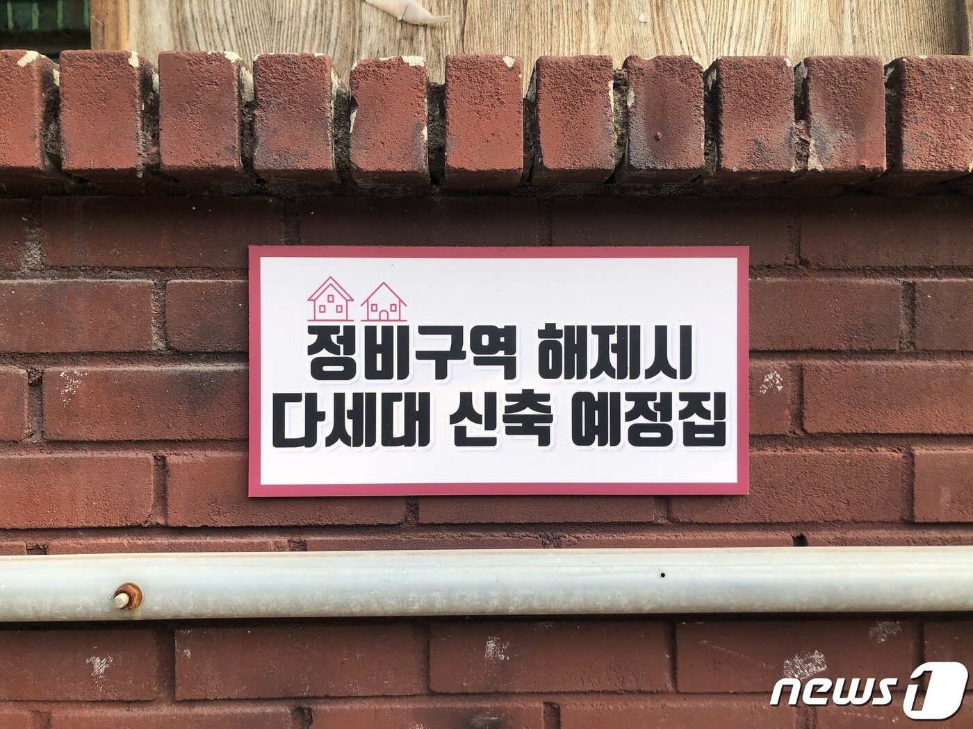 본문 이미지 - 경기 의왕 내손가구역의 한 주택에 '정비구역 해제시 다세대 신축예정집' 안내판이 붙어있는 모습 ⓒ 뉴스1