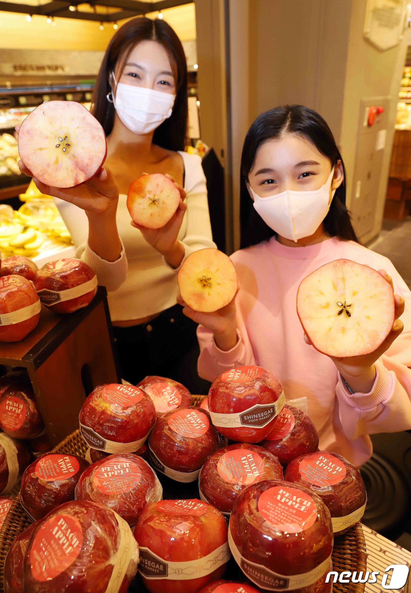 (서울=뉴스1) 유승관 기자 = 모델들이 22일 서울 중구 신세계백화점 본점에서 겉은 사과 모양이지만 속은 복숭아처럼 붉은 빛깔의 '복숭아 사과'를 백화점 업계 최초로 선보이고 있 …