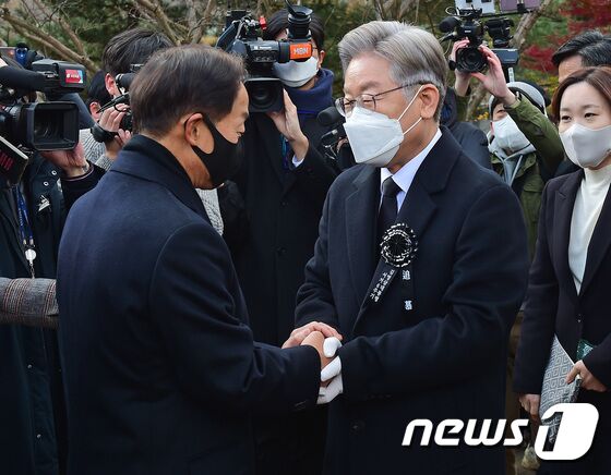 이재명 더불어민주당 대선 후보가 22일 서울 동작구 국립서울현충원 내 김영삼 전 대통령 묘역에서 열린 6주기 추모식에서 김 전 대통령의 차남인 김현철 김영삼민주센터 상임이사와 인사를 나누고 있다. 2021.11.22/뉴스1 © News1 국회사진취재단