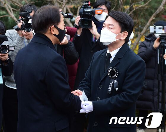 안철수 국민의당 대선 후보가 22일 서울 동작구 국립서울현충원 내 김영삼 전 대통령 묘역에서 열린 6주기 추모식에서 김 전 대통령의 차남인 김현철 김영삼민주센터 상임이사와 인사를 나누고 있다. 2021.11.22/뉴스1 © News1 국회사진취재단