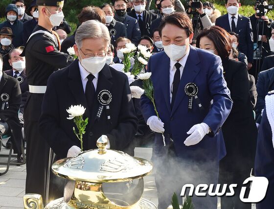 이재명 더불어민주당 대선 후보와 윤석열 국민의힘 대선 후보가 22일 서울 동작구 국립서울현충원 내 김영삼 전 대통령 묘역에서 열린 6주기 추모식에서 헌화를 하고 있다. 2021.11.22/뉴스1 © News1 국회사진취재단
