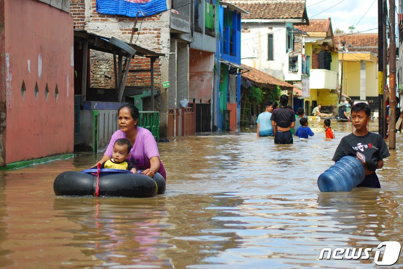 (반둥 AFP=뉴스1) 우동명 기자 = 28일(현지시간) 폭우가 쏟아진 인도네시아 반둥에서 주민들이 물에 잠긴 거리를 고무 보트를 타고 이동하고 있다.ⓒ AFP=뉴스1