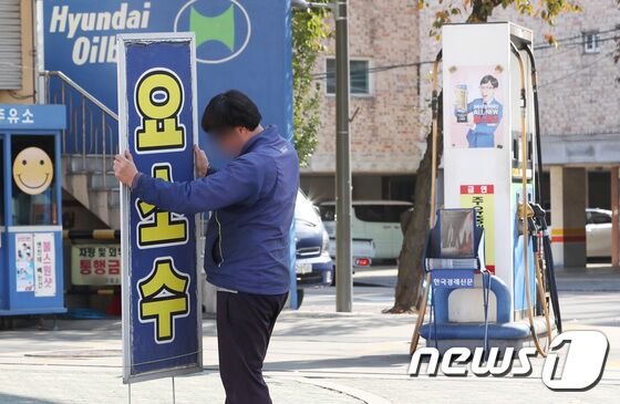 요소수 품귀 현상이 계속된 3일 서울의 한 주유소에서 요소수가 동나자 관계자가 관련 팻말을 제거하고 있다. 이날 해당 주유소 관계자는