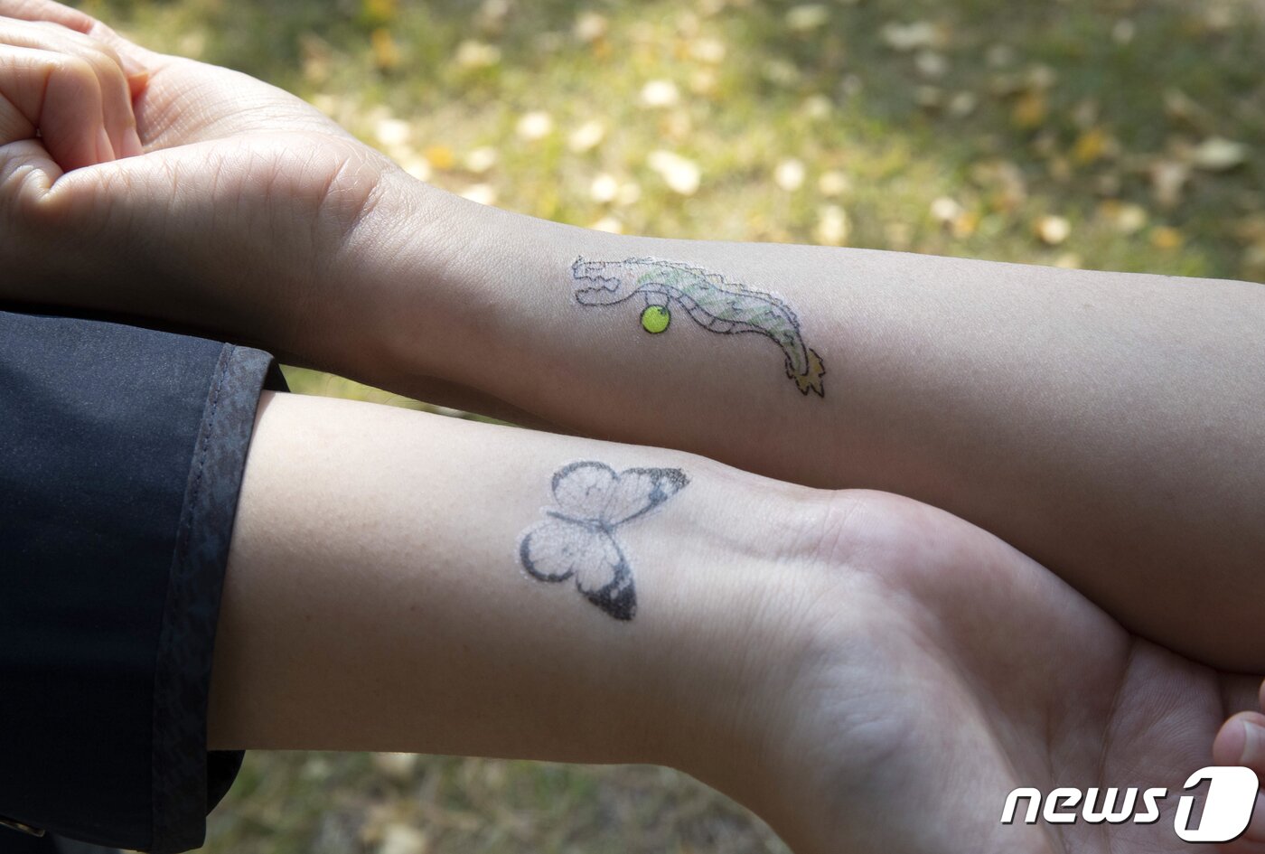 본문 이미지 - 3일 국회 의원회관 앞에서 열린 타투 오픈베타서비스 행사에 참여한 시민들이 타투 스티커를 보여주고 있다. 2021.11.3/뉴스1 ⓒ News1 오대일 기자