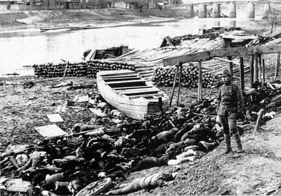 1937년 12월 난징 서문 근처의 강가에 버려진 중국인 시체들을 일본병사가 쳐다보고 있다 / 사진출처 = 위키피디아