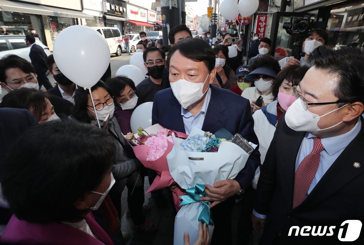 본문 이미지 - 윤석열 국민의힘 대선 경선후보가 4일 오후 경기도 연천군 전곡시장을 방문해 당직자들에게 꽃다발을 받고 있다. 2021.11.4/뉴스1 ⓒ News1 구윤성 기자
