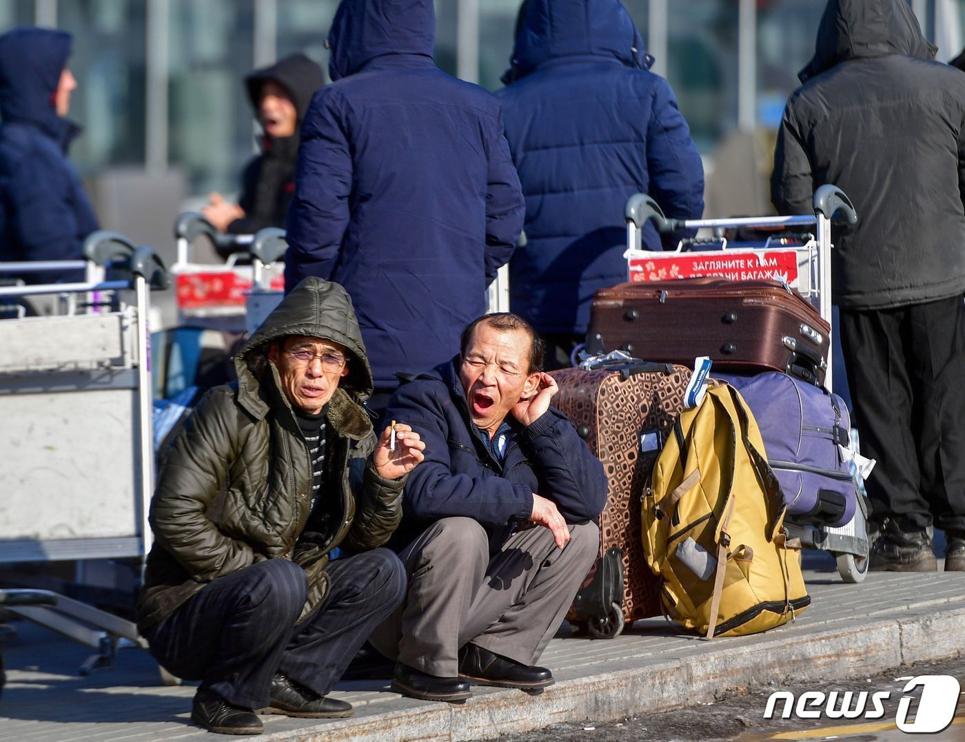 본문 이미지 - 지난 2019년 12월22일 러시아 블라디보스토크 공항에서 귀국 비행기를 기다리고 있는 북한 근로자들. ⓒ AFP=뉴스1