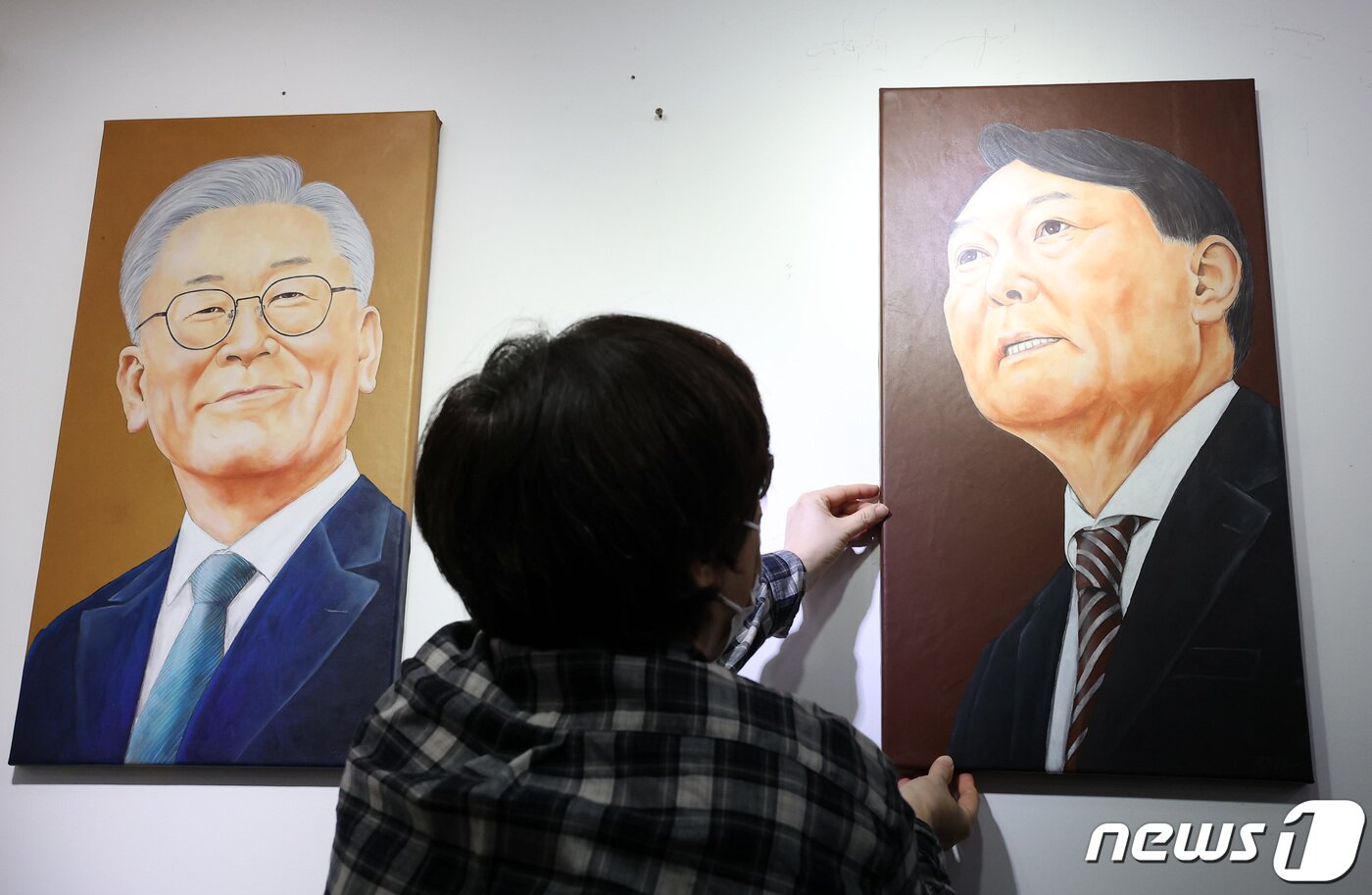 본문 이미지 - 5일 오후 서울시내 한 갤러리에서 관계자가 윤석열 국민의힘 대통령 후보의 초상화를 이재명 더불어민주당 대통령 후보의 초상화 옆에 전시하고 있다. 2021.11.5/뉴스1 ⓒ News1 조태형 기자