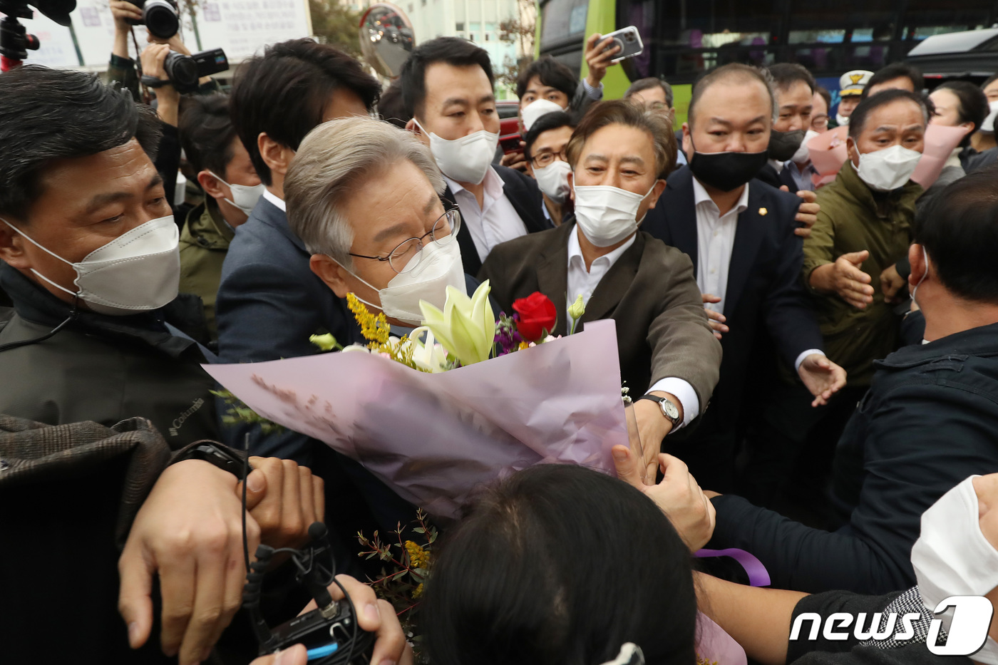 (대구=뉴스1) 공정식 기자 = 이재명 더불어민주당 대선 후보가 5일 오후 대구 중구 서문시장에 도착해 많은 인파 속에서 환영의 꽃다발을 받고 있다. 2021.11.5/뉴스1