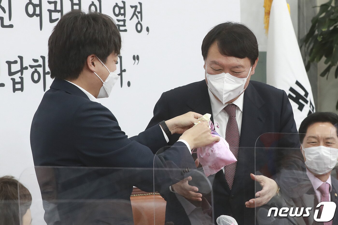 본문 이미지 - 이준석 국민의힘 대표(왼쪽)가 8일 오전 서울 여의도 국회에서 열린 최고위원회의에서 윤석열 대선후보에게 비단주머니를 전달하고 있다. 2021.11.8/뉴스1 ⓒ News1 이동해 기자