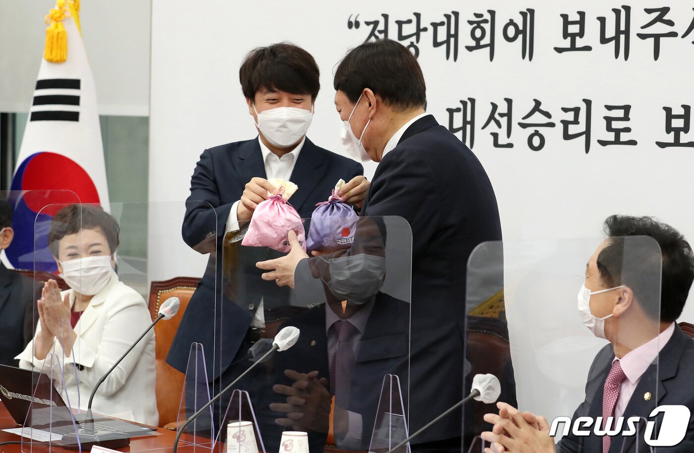 본문 이미지 - 이준석 국민의힘 대표(왼쪽)가 8일 오전 서울 여의도 국회에서 열린 최고위원회의에서 윤석열 대선후보에게 비단주머니를 전달하고 있다. 2021.11.8/뉴스1 ⓒ News1 이동해 기자