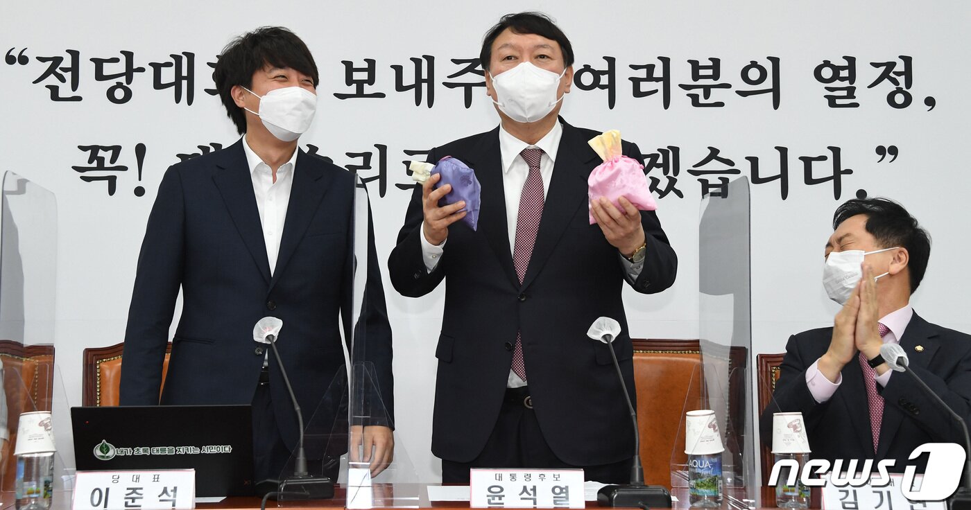 본문 이미지 - 윤석열 국민의힘 대선후보(왼쪽 두 번째)가 지난 8일 오전 서울 여의도 국회에서 열린 최고위원회의에서 이준석 대표에게 비단주머니를 받은 후 발언하고 있다. 2021.11.8/뉴스1 ⓒ News1 이동해 기자