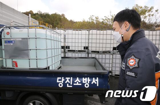 전국적으로 차량용 요소수 수급난이 빚어지고 있는 가운데 9일 충남 논산에 위치한 요소수 생산업체에서 당진소방서 소속 소방관이 차량에 옮겨진 유소수를 바라보고 있다. 2021.11.9/뉴스1 © News1 김기태 기자