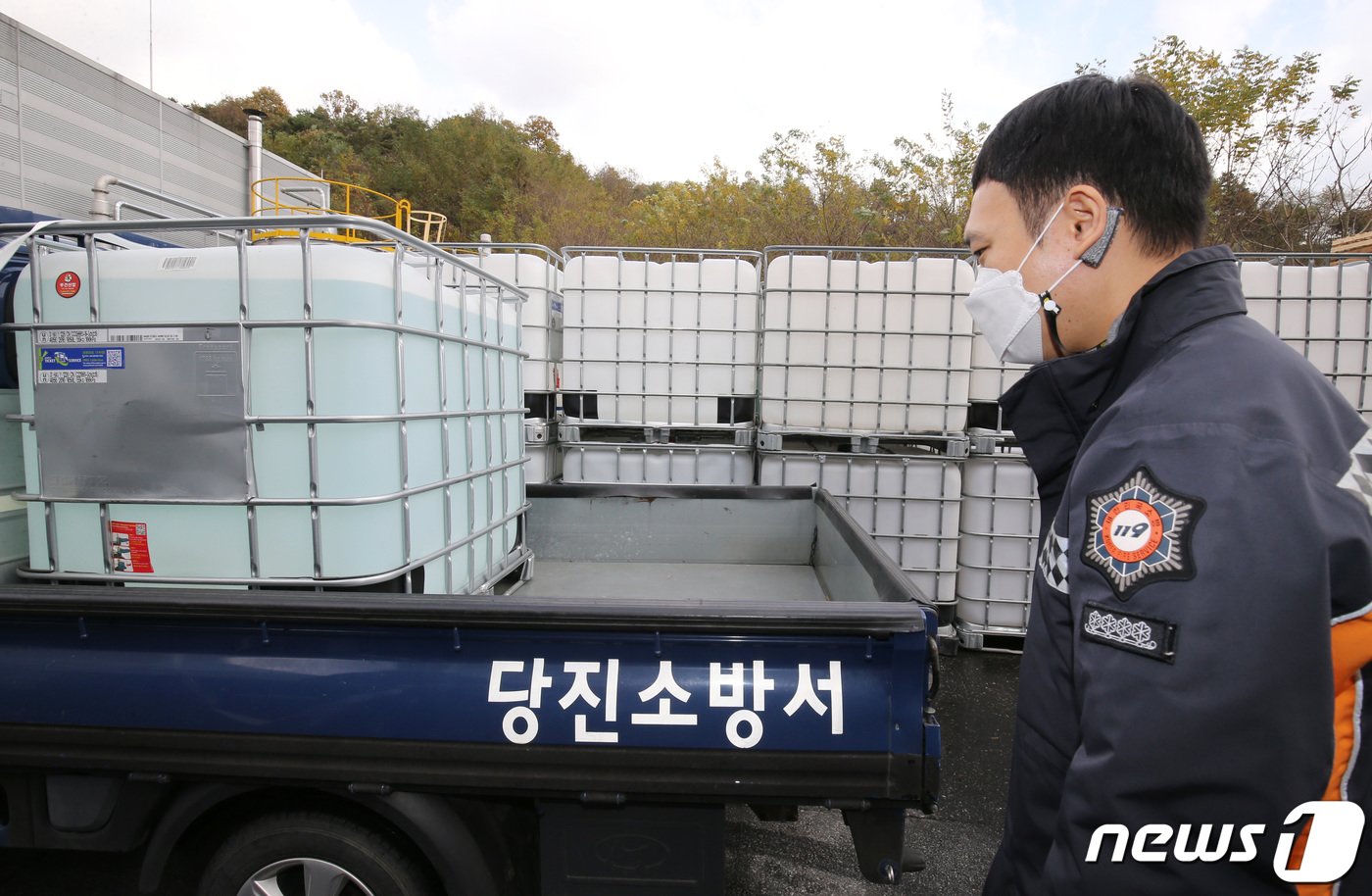 본문 이미지 - 전국적으로 차량용 요소수 수급난이 빚어지고 있는 가운데 9일 충남 논산에 위치한 요소수 생산업체에서 당진소방서 소속 소방관이 차량에 옮겨진 유소수를 바라보고 있다. 2021.11.9/뉴스1 ⓒ News1 김기태 기자