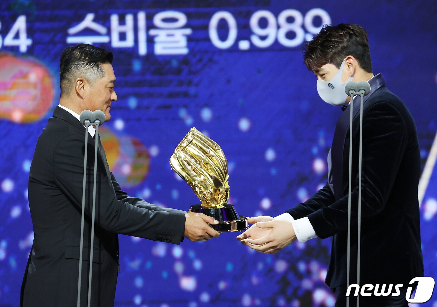 본문 이미지 - 이정후(키움)가 10일 오후 서울 강남구 코엑스 오디토리움에서 열린 2021 신한은행 SOL KBO 골든글러브 시상식에서 외야수 부문 골든글러브를 아버지인 이종범 LG 코치에게 전달받고 있다. 2021.12.10/뉴스1 ⓒ News1 조태형 기자