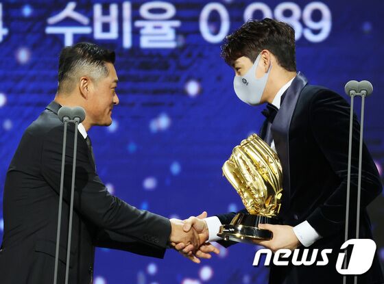 이정후(키움)가 10일 오후 서울 강남구 코엑스 오디토리움에서 열린 2021 신한은행 SOL KBO 골든글러브 시상식에서 외야수 부문 골든글러브를 아버지인 이종범 LG 코치에게 전달받고 있다. 2021.12.10/뉴스1 © News1 조태형 기자