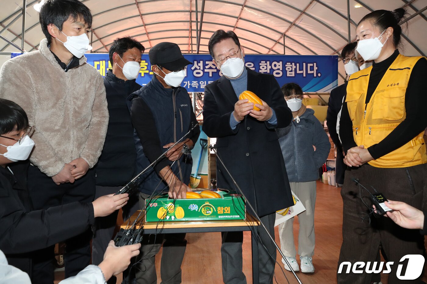본문 이미지 - 매타버스(매주 타는 민생버스) 다섯번째 행선지로 고향인 대구·경북(TK)을 찾은 이재명 더불어민주당 대선 후보가 13일 오전 경북 성주군 참외 농가를 방문해 성주 참외 모종심기를 체험한 후 농민들과 참외를 들고 대화하고 있다. 2021.12.13/뉴스1 ⓒ News1 오대일 기자