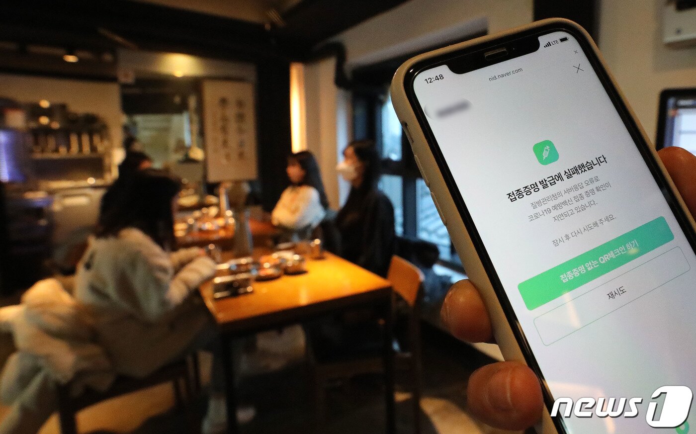본문 이미지 - 방역패스(접종증명·음성확인제)의 계도기간이 끝나고 의무화가 시작된 13일 서울시내의 한 식당에서 손님이 접종증명 발급 오류 화면을 보이고 있다. 이날 백신 접종을 증명하는 시스템에 일부 오류가 발생해 백신 QR 코드 인증 화면에는 '질병관리청의 서버응답 오류로 코로나19 예방백신 접종 증명 확인이 지연되고 있습니다'고 표시됐다. 2021.12.13/뉴스1 ⓒ News1 임세영 기자