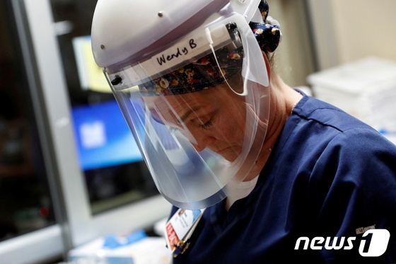 미국 플로리다 사라로타 메모리얼 종합병원 한 간호사가 중환자실 코로나 격리 병동에 들어가기 전 지친 얼굴로 바닥을 내려다 보고 있다. 2021. 9. 21. © 로이터=뉴스1 © News1 최서윤 기자