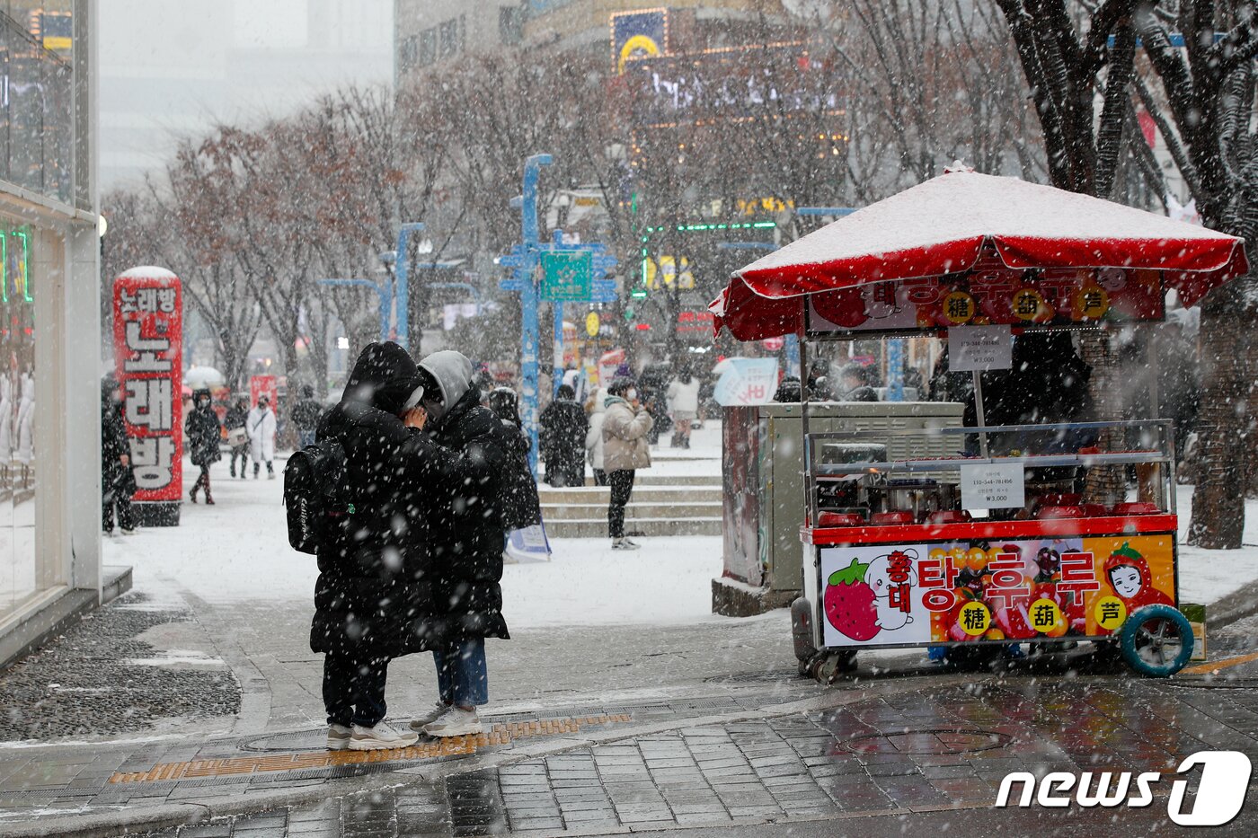 본문 이미지 - 올겨울 첫 대설주의보가 내린 18일 오후 서울 마포구 홍대 인근에서 시민들이 눈을 맞고 있다. 2021.12.18/뉴스1 ⓒ News1 안은나 기자